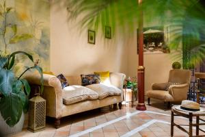 a living room with a couch and two chairs at CH Apartments Boutique in Seville