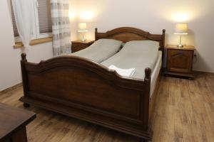 1 dormitorio con 1 cama de madera y 2 mesitas de noche en Siedlisko Miluki, en Ełk