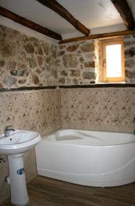 ein Badezimmer mit einer Badewanne und einem Waschbecken in der Unterkunft Hangjik (Little Inn) 