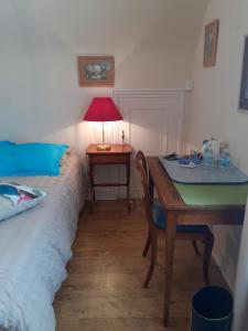 1 dormitorio con 1 cama y escritorio con lámpara en La Voile Bleue, en La Trinité-sur-Mer