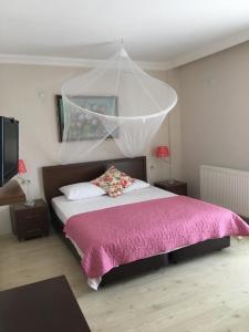 a bedroom with a bed with a pink blanket at Melaike Hotel in Foça
