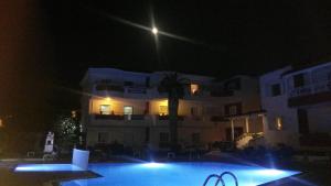 a swimming pool at night with a building at Polichrono in Polychrono