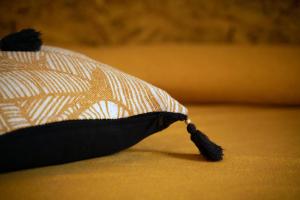 a black and white hat with a tassel on a bed at Amaranto in Maratea