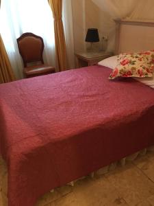 a bedroom with a bed with a red blanket and a chair at Melaike Hotel in Foça