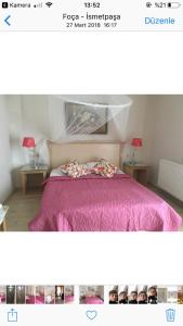 a picture of a bedroom with a bed with a pink blanket at Melaike Hotel in Foça