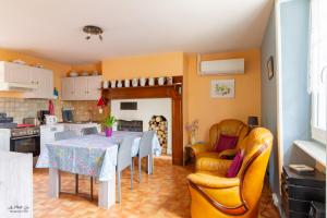 Gite Des Croix Bancaud في Jumilhac-le-Grand: مطبخ مع طاولة طعام وكراسي