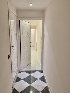 een hal met een witte deur en een zwart-witte tegelvloer bij Lerici WhiteHouse in Lerici