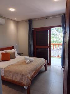- une chambre avec un lit et une porte coulissante en verre dans l'établissement Casa Verde Maré, à Pipa