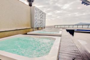 two hot tubs on the roof of a building at Hotel D'sintra in Balneário Camboriú