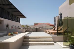a balcony with stairs and tables on a building at Fonte d'Oro Luxury Rooms in Rethymno Town