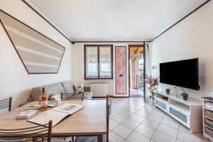 a living room with a table and a television at Al Tulipano in Polpenazze del Garda