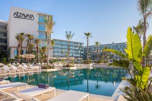 uma imagem de um hotel com piscina e cadeiras em Atzavara Hotel & Spa em Santa Susanna