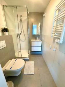 a bathroom with a shower and a toilet and a sink at Starter III in Wrocław