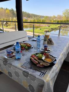 a table with plates of food and drinks on it at Rybaczówka Golub-Dobrzyń in Golub-Dobrzyń