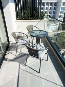 a balcony with three chairs and a table on a roof at Sea view Apartment Elite2 in Sarandë