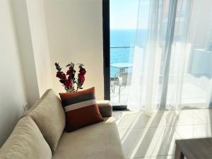 a living room with a couch and a large window at Sea view Apartment Elite2 in Sarandë