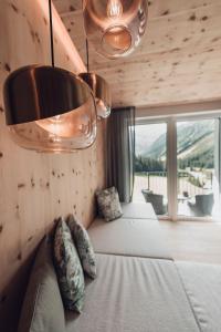 a bedroom with two beds and a large window at Alpine Resort Sportalm in Sankt Leonhard im Pitztal