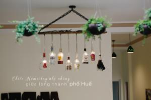 フエにあるHue Eco Homestayの天井にぶら下がるワインボトルシャンデリア