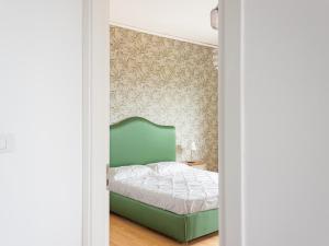 a bedroom with a green bed and a wall at Panorama Love to Stay in Ercolano