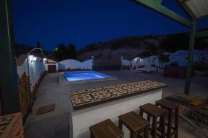 a patio with a swimming pool at night at CASA CUEVA LOS HONORIOS in Cortes de Baza