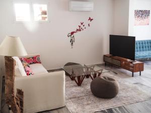 a living room with a white couch and a tv at Villa Vidal in Sant Josep de sa Talaia