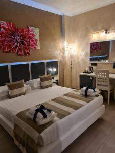 a bedroom with a large bed and a desk at Albis Rooms Guest House in Fiumicino