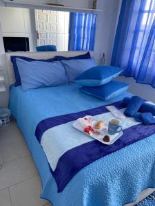 Una cama azul con una bandeja de comida. en Casa Yurena en Playa Honda