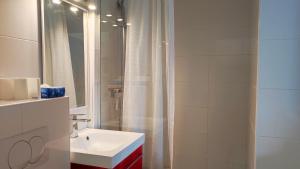 a white bathroom with a sink and a mirror at Belle Suite Apt in Biarritz +6 photos