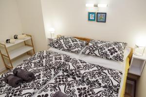 a bedroom with a bed with black and white sheets and pillows at ĐILL Apartment in Subotica