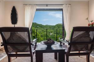 a dining room with a table and two chairs and a window at Firefly Estate Bequia in Crescent Beach