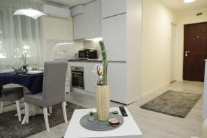 a living room with a table with a vase at ĐILL Apartment in Subotica