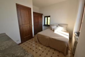 sypialnia z łóżkiem i drewnianymi drzwiami w obiekcie Holiday Home Chiavari w mieście Chiavari