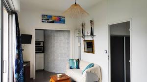 a living room with a white chair and a table at Belle Suite Apt in Biarritz