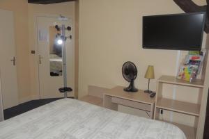 a bedroom with a bed and a flat screen tv at Belle Epoque in Chinon