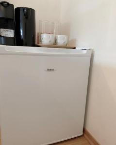 a white refrigerator with a shelf on top of it at Budget Small Room City Centre in Oslo