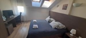 1 dormitorio con 1 cama con sábanas azules y almohadas blancas en Hotel Bartnik, en Pszczółki