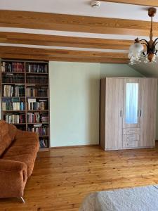 a living room with a couch and a book shelf at Domo Vila in Klaipėda