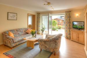 ein Wohnzimmer mit einem Sofa und einem Tisch in der Unterkunft Ferienwohnungen Franziska Hackl in Bad Birnbach