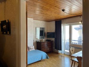 1 dormitorio con 1 cama, TV y ventana en Chesa Sonnalpine B 33 en St. Moritz