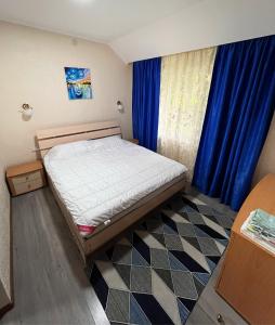 1 dormitorio con cama y cortina azul en Deluxe Royal Beach, en Chok-Tal