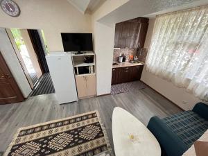 a living room with a refrigerator and a kitchen at Deluxe Royal Beach in Chok-Tal