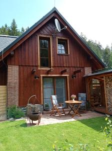 a wooden house with a patio and a table at Stodola Harrachov in Harrachov