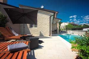 un patio con banco, sombrilla y piscina en Vila Una with private pool near Rovinj - open 2022, en Rovinjsko Selo