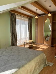 a bedroom with a large bed and a round mirror at Domo Vila in Klaipėda