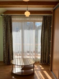 a coffee table in front of a large window at Domo Vila in Klaipėda