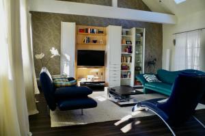 een woonkamer met een bank en stoelen en een tv bij Für Liebhaber des Besonderen in Trier