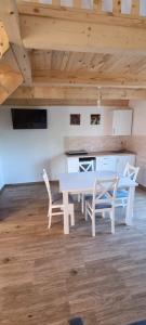 Biały stół i 2 krzesła w pokoju w obiekcie Chatki Niwkii u Zbója Studio z antresolą w Krościenku