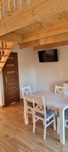 クロシチェンコにあるChatki Niwkii u Zbója Studio z antresoląの木製の天井の客室で、テーブルと椅子が備わります。