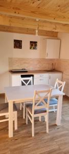 y cocina con mesa de comedor blanca y sillas. en Chatki Niwkii u Zbója Studio z antresolą en Krościenko