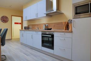 a kitchen with white cabinets and a stove at Wohnung "Stralsund" in Gützkow